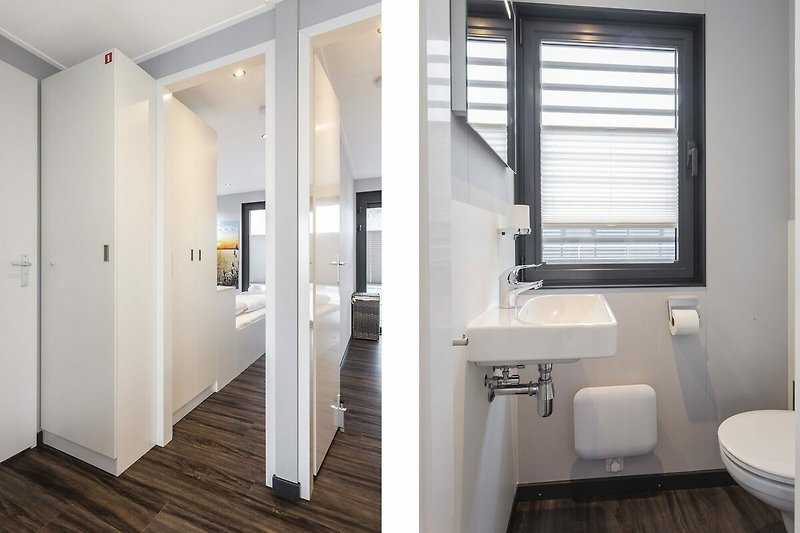 Modernes Badezimmer mit Glasdusche, Holztür und Metallarmaturen.