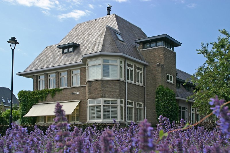 Großes Anwesen mit gepflegtem Garten und klassischer Architektur.