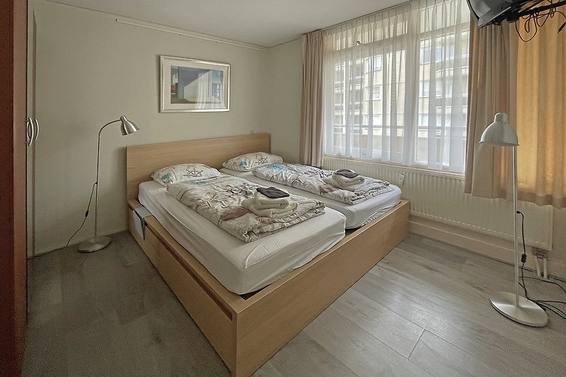 Stilvolles Schlafzimmer mit Holzmöbeln und eleganten Vorhängen.