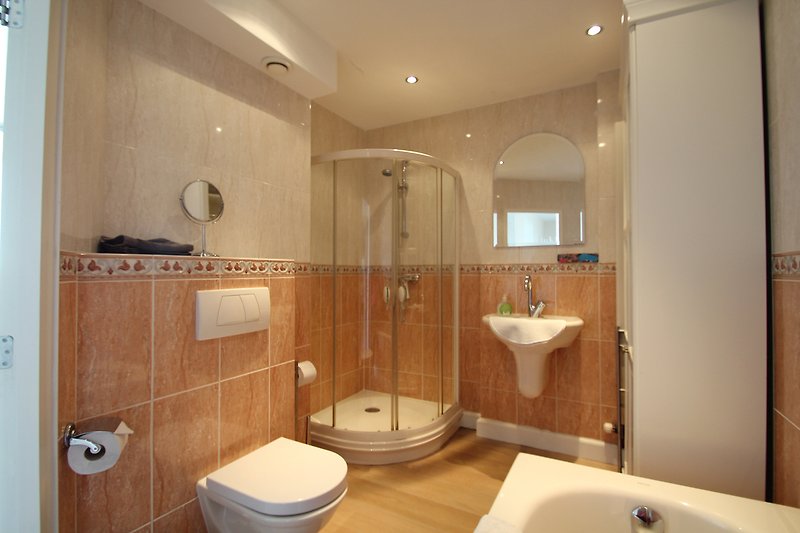 Gemütliches Badezimmer mit lila Beleuchtung, Spiegel und Waschbecken.