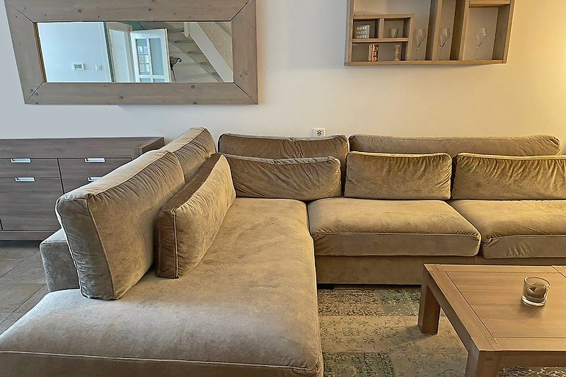Gemütliches Wohnzimmer mit brauner Couch und Holzmöbeln