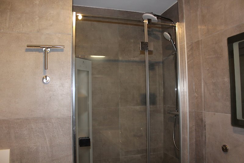 Schöne Dusche mit stilvoller Glaswand und elegantem Armaturen.