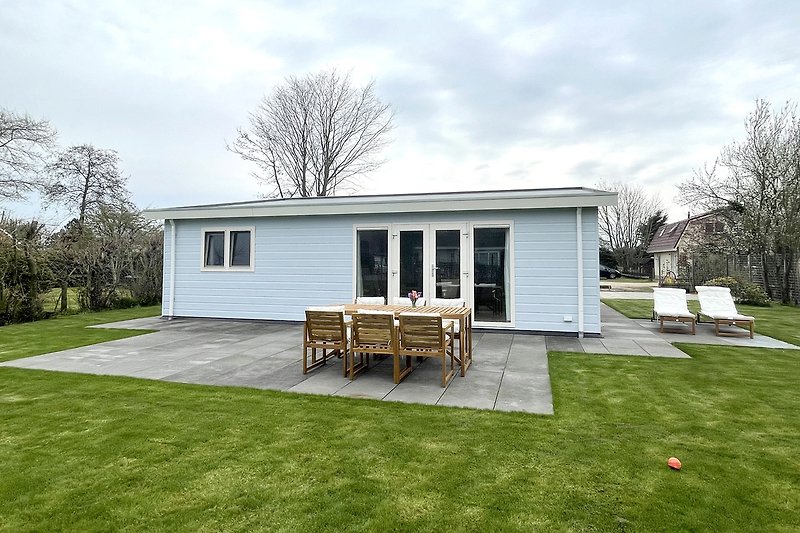 Ländliches Haus mit Garten, Veranda und Bäumen.