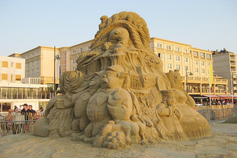 Moderes Strandbild mit Skulptur, Statue, Sand und Meer.