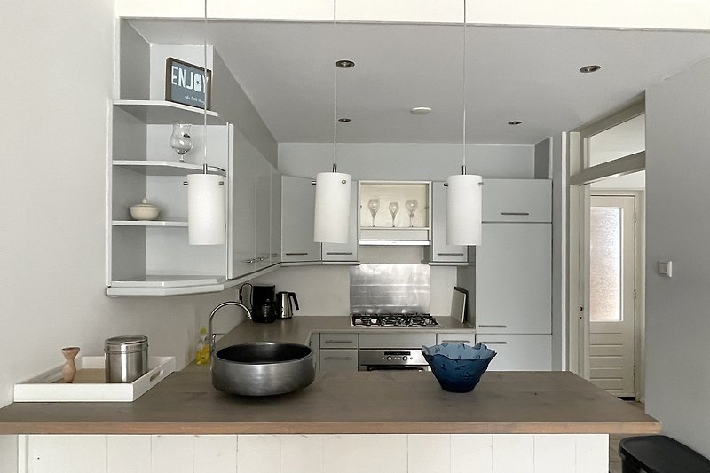 Moderne Küche mit Holzschränken, Granit-Arbeitsplatte und stilvoller Einrichtung.