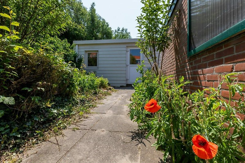 Rustikales Cottage mit blühendem Garten und ländlicher Umgebung.