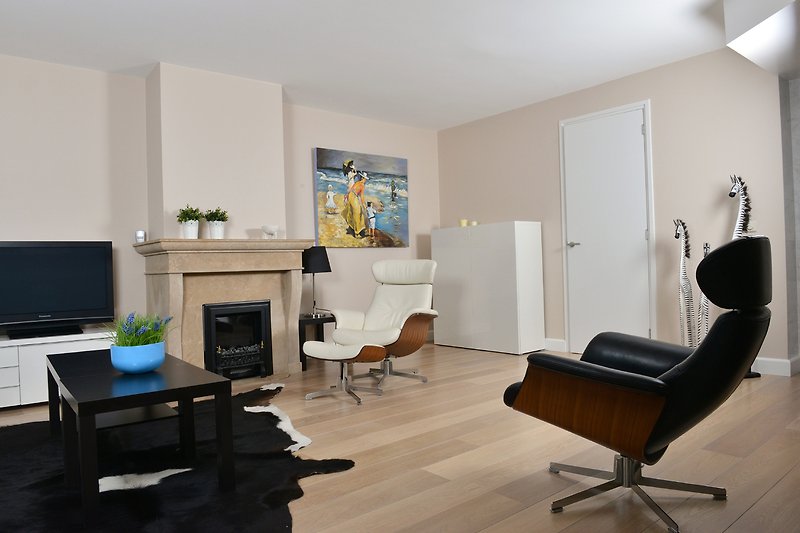 Modernes Wohnzimmer mit stilvollen Möbeln, gemütlicher Beleuchtung und elegantem Interieur. Eine Pflanze verleiht dem Raum Frische.