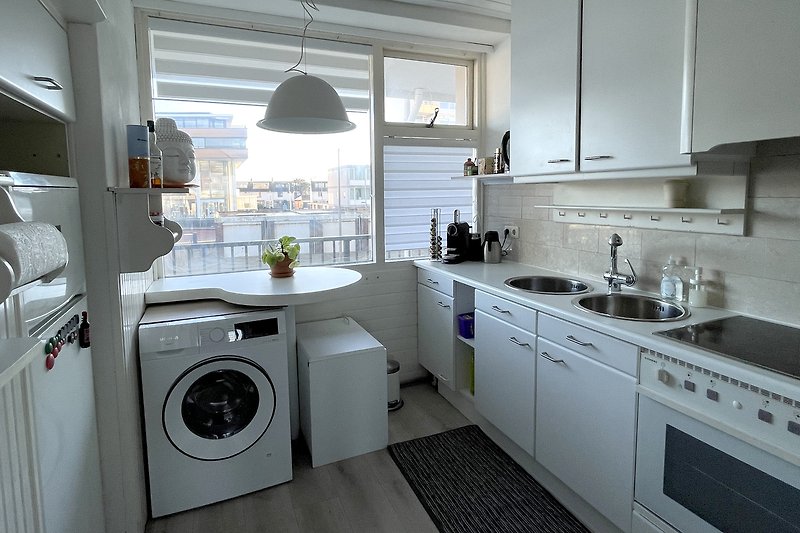 Moderne Küche mit Waschmaschine, Trockner und Arbeitsplatte.
