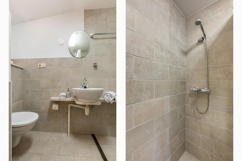 Modernes Badezimmer mit stilvoller Beleuchtung und Glasdusche.