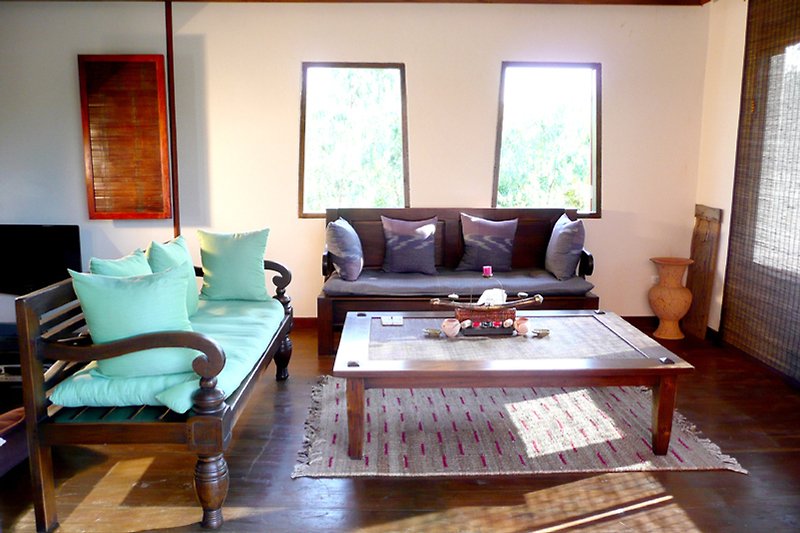 Wohnzimmer mit bequemer Couch, Tisch und Fenster. Gemütliche Einrichtung.