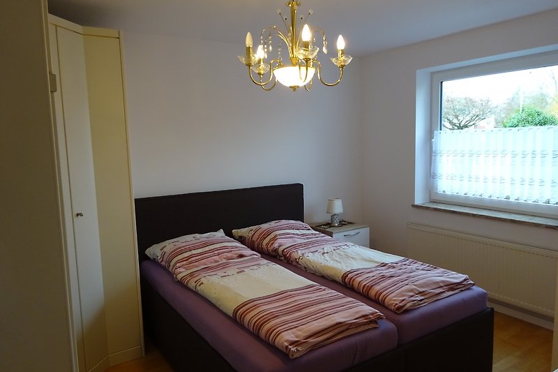 Schlafzimmer mit bequemem Bett, stilvoller Beleuchtung und gemütlichen Textilien.