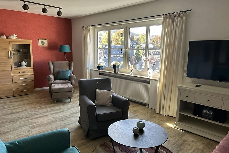 Gemütliches Wohnzimmer mit stilvoller Einrichtung und TV.