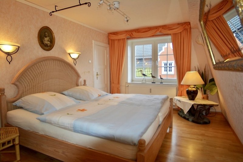 Schlafzimmer mit bequemem Bett, Holzmöbeln und Lampen. Gemütliche Atmosphäre.