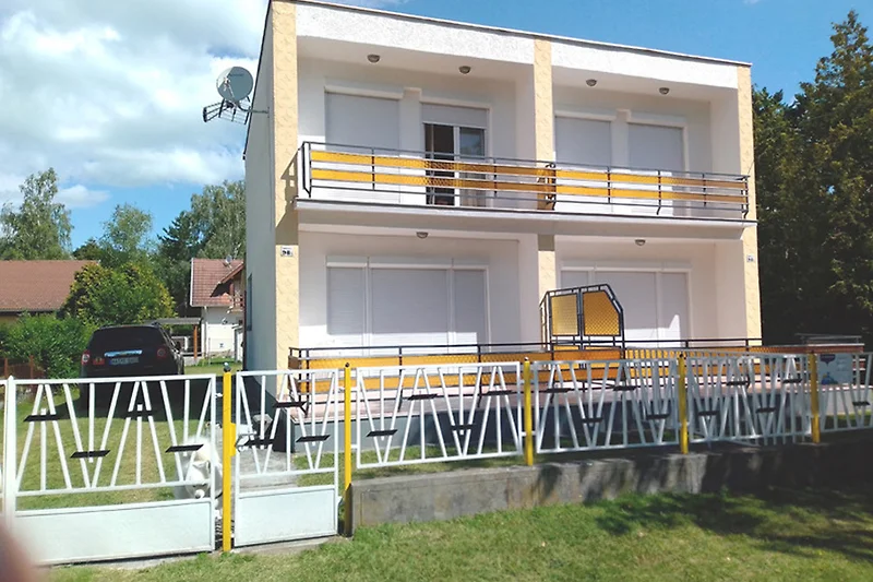 Überdachte Veranda mit Geländer und Zaun für entspannte Auszeiten.