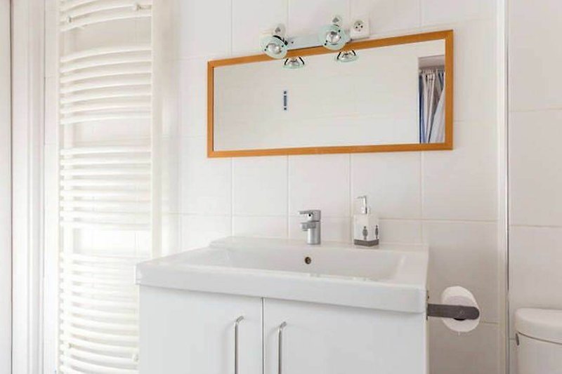 salle de bain moderne avec miroir, lavabo et robinet.