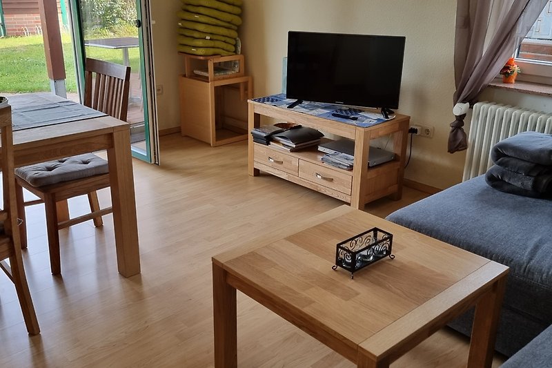Gemütliches Wohnzimmer mit Holzmöbeln und Fernseher.