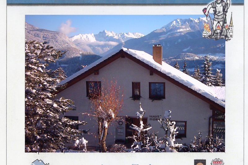 Schönes Ferienhaus mit Blick auf verschneite Berge und winterliche Landschaft.