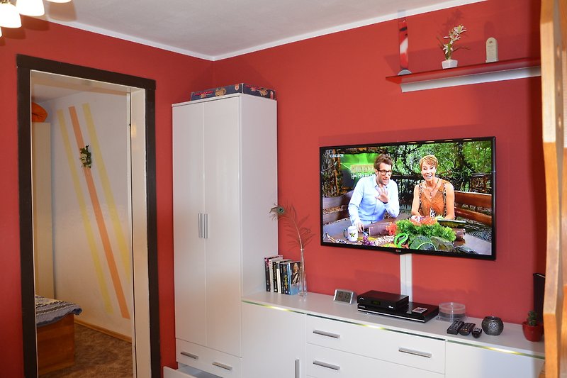 Wohnzimmer mit TV, Holz und Pflanzen. Gemütliche Einrichtung.