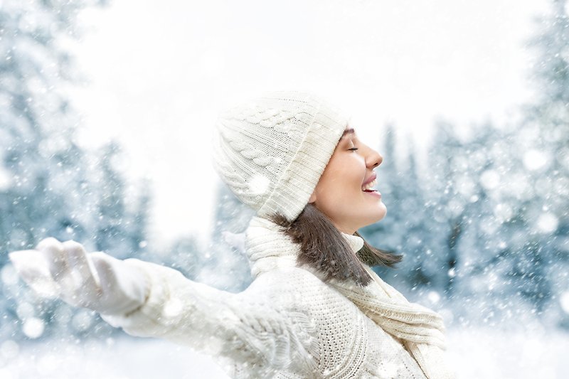 Winterlandschaft mit fröhlichen Menschen, die im Schnee spielen und lachen.