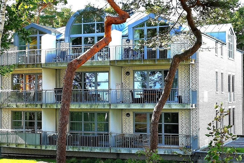 Schönes Haus mit grüner Umgebung und charmantem Balkon.