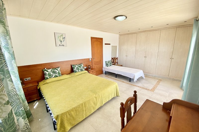 Modernes Schlafzimmer mit stilvollen Möbeln, gemütlichem Bett und Holzboden. Klare Linien.