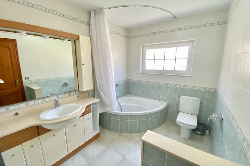 Modernes Badezimmer mit Badewanne, Waschbecken und Spiegel. Klares Design.