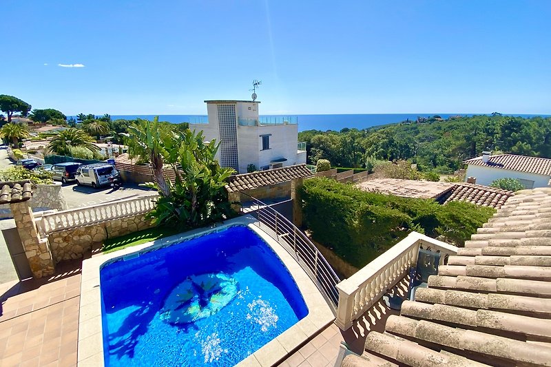 Moderne Villa mit Pool, tropischer Landschaft und Meerblick.