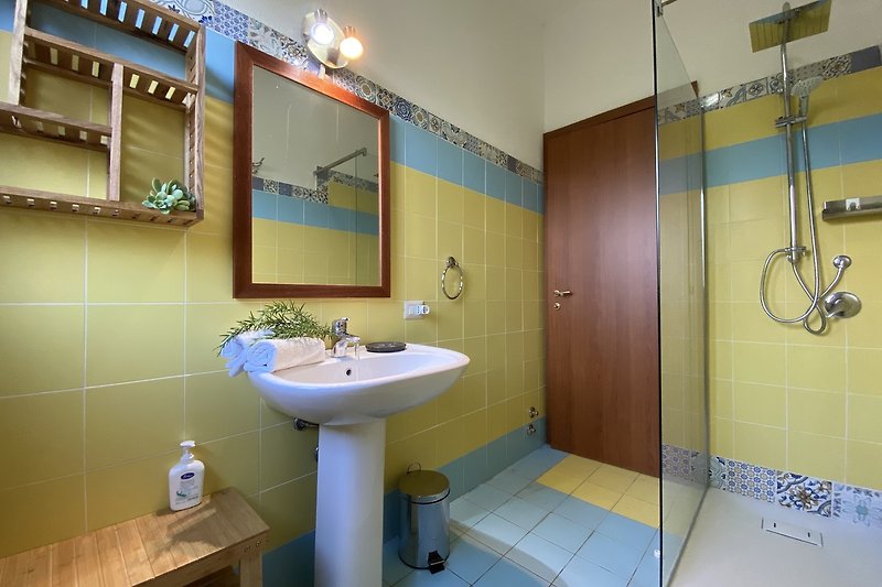 Modernes Badezimmer mit lila Akzenten, Dusche und Spiegel.