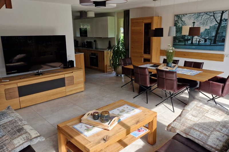 Gemütliches Wohnzimmer mit bequemer Couch, Fernseher und Pflanze.