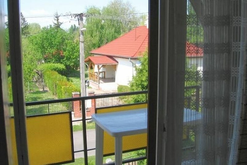 Ein charmantes Haus mit einem blühenden Garten und einem gemütlichen Balkon.