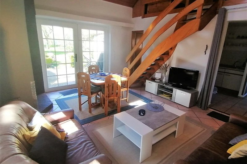 Gemütliches Wohnzimmer mit bequemen Möbeln und Holzboden.
