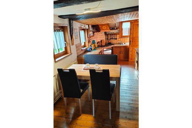 Gemütliche Küche mit Holzmöbeln und Fenstern.