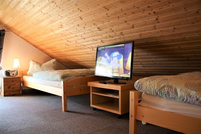 Schlafboden mit Betten und kleinem TV