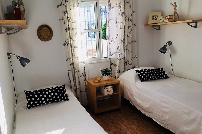 Gemütliches Schlafzimmer mit stilvoller Einrichtung und grünen Pflanzen.