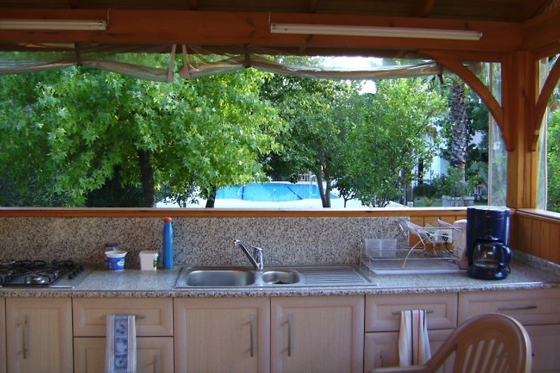 Cucina da giardino con vista sulla piscina