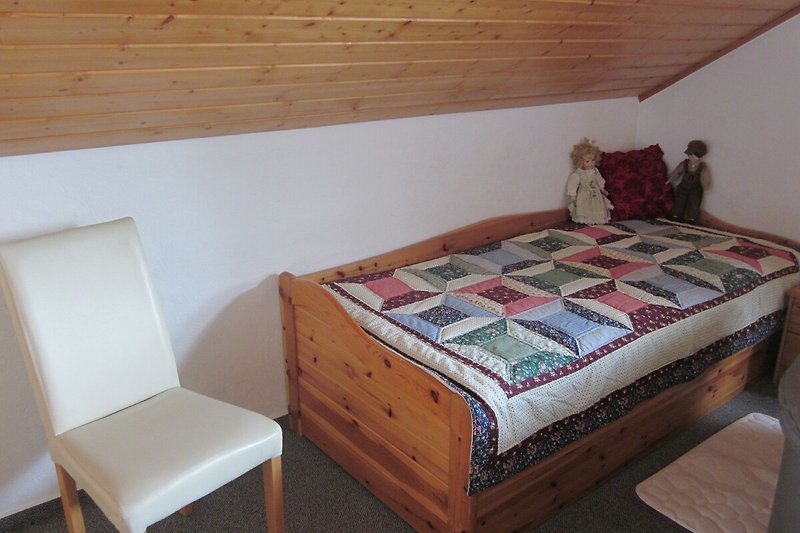 Gemütliches Schlafzimmer mit Holzmöbeln und komfortablem Bett.