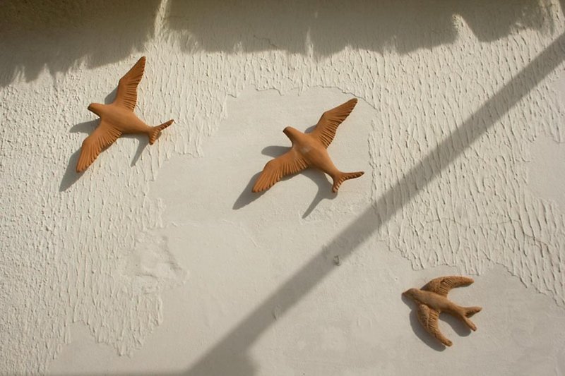 Schwalben aus Terracotta an der Hauswand