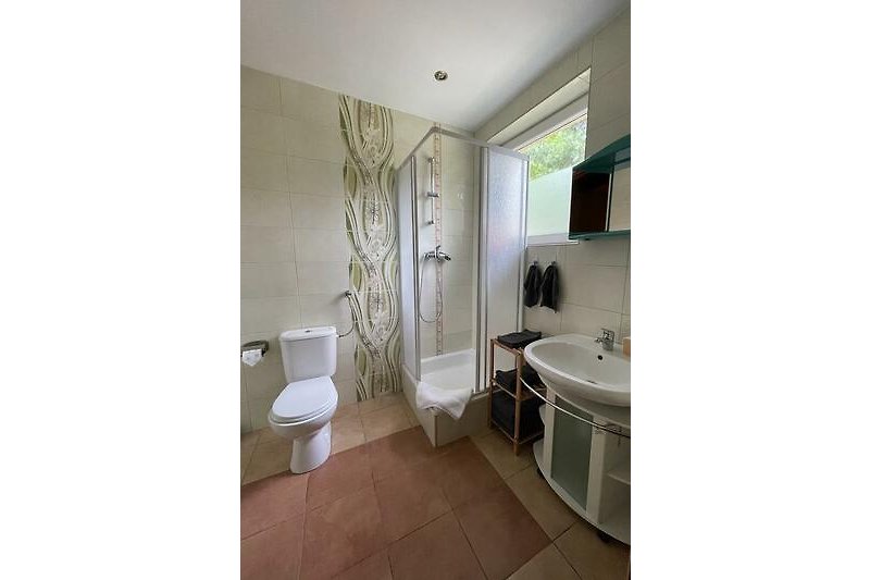 Schönes Badezimmer mit lila Akzenten und stilvoller Beleuchtung.