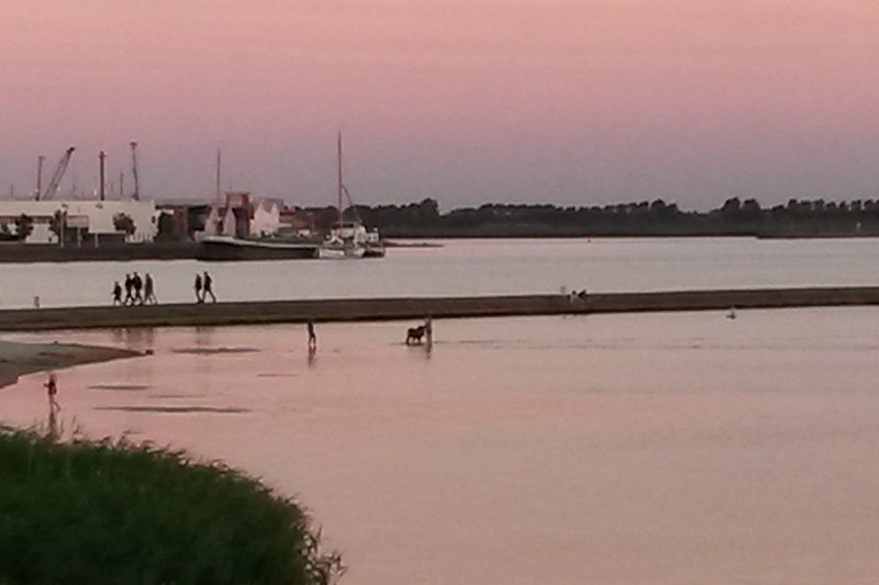Eine ruhige Abendstimmung am See mit Boot und rotem Himmel.