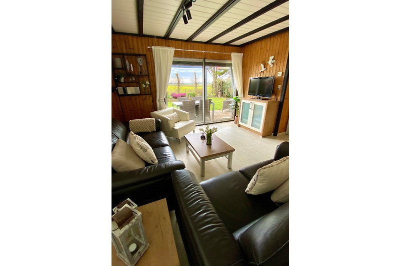 Wohnzimmer mit bequemer Couch, Tisch, Fenster und Lampe.