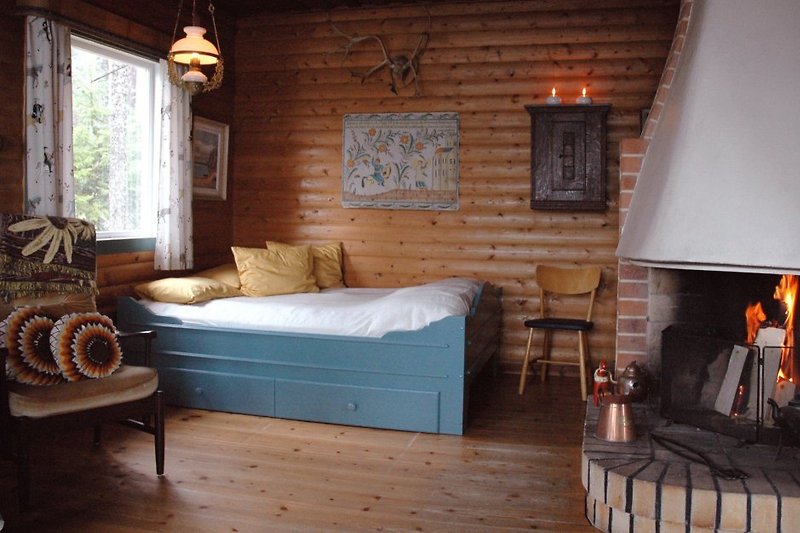 The living room offers a breath-taking view over the lake with a fireplace to gather around during evenings. In the back of the room is a Queen bed (140 cm) of old Dalarna style.