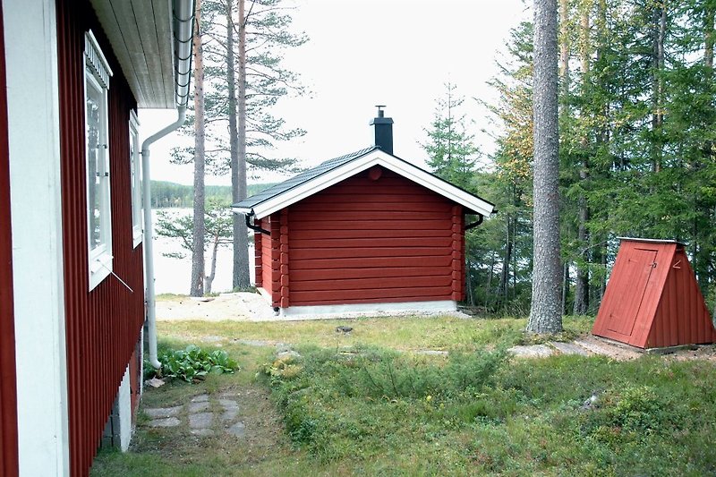 The sauna building is located just a few meters from the lake shore. To the right is the water well house.