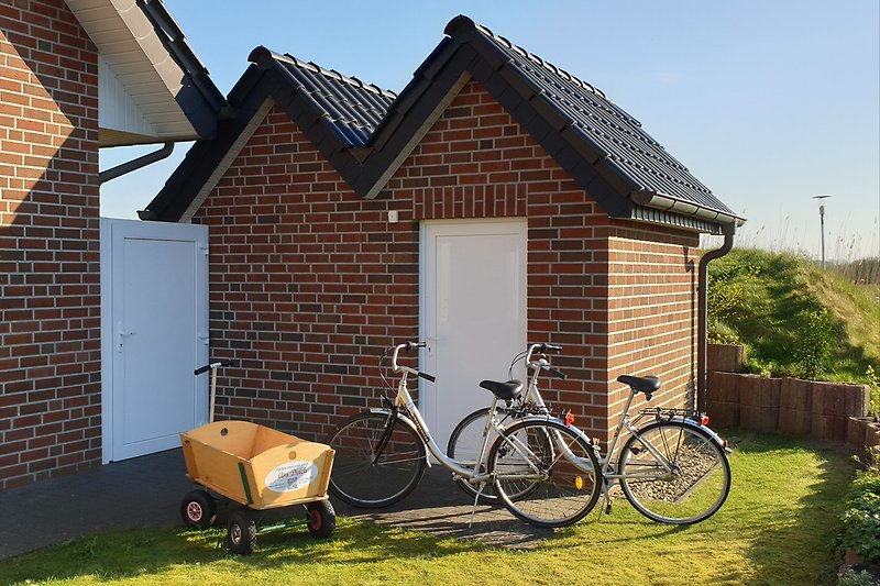 The bicycle shed including 2 bicycles and a handcart.