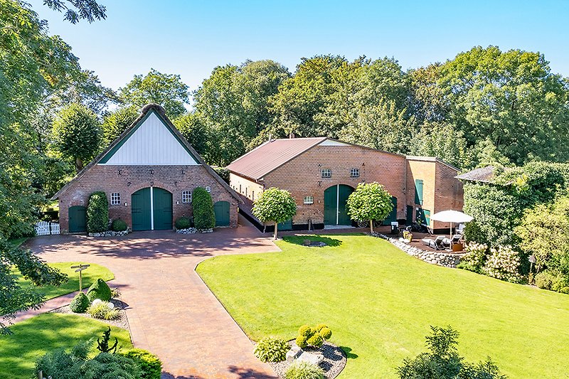 Gepflegter Garten mit Bäumen und gemütlicher Terrasse.