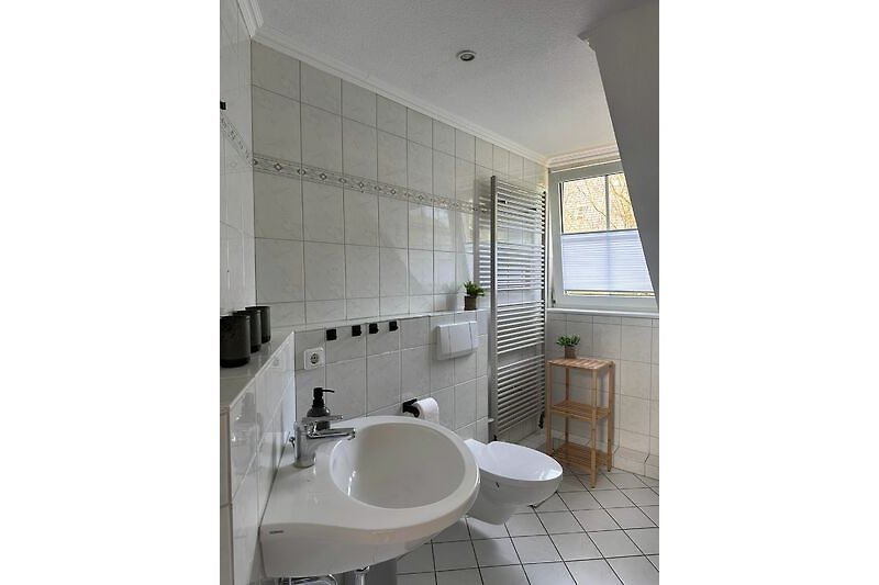 Modernes Badezimmer mit Spiegel, Waschbecken, Badewanne und Dusche im OG