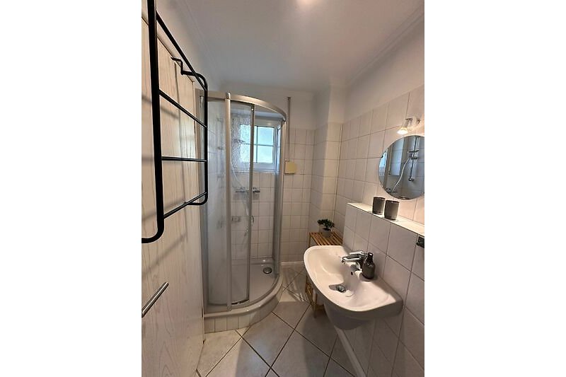 Modernes Badezimmer mit Spiegel, Waschbecken und Dusche im EG