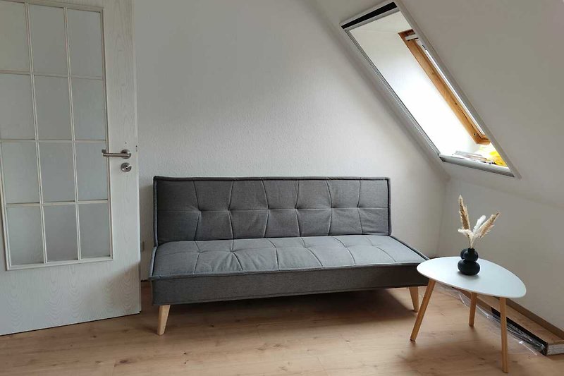 Modernes Schlafzimmer mit bequemer Couch und stilvoller Einrichtung.