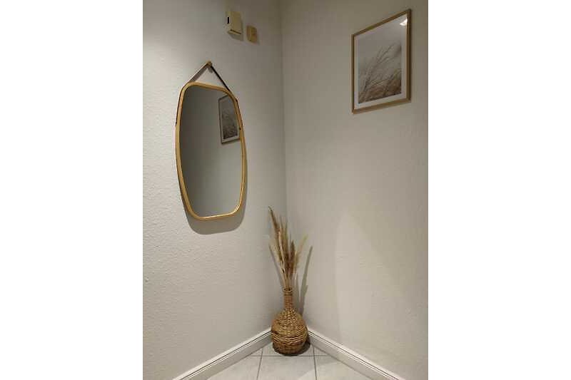 Kunstvolle Einrichtung mit Spiegel, Holz und Pflanzen im Flur EG