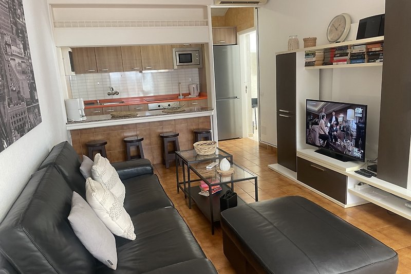Gemütliches Wohnzimmer mit bequemer Couch und Fernseher