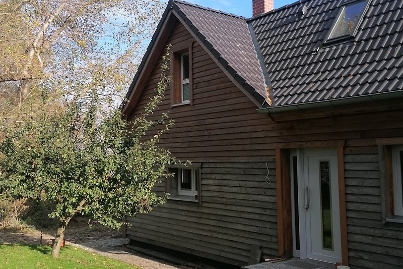 Ein charmantes Haus mit einem schönen Garten und einem gemütlichen Holzhaus.